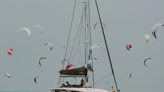 Kites flying above a catamaran in a Cyclades bay