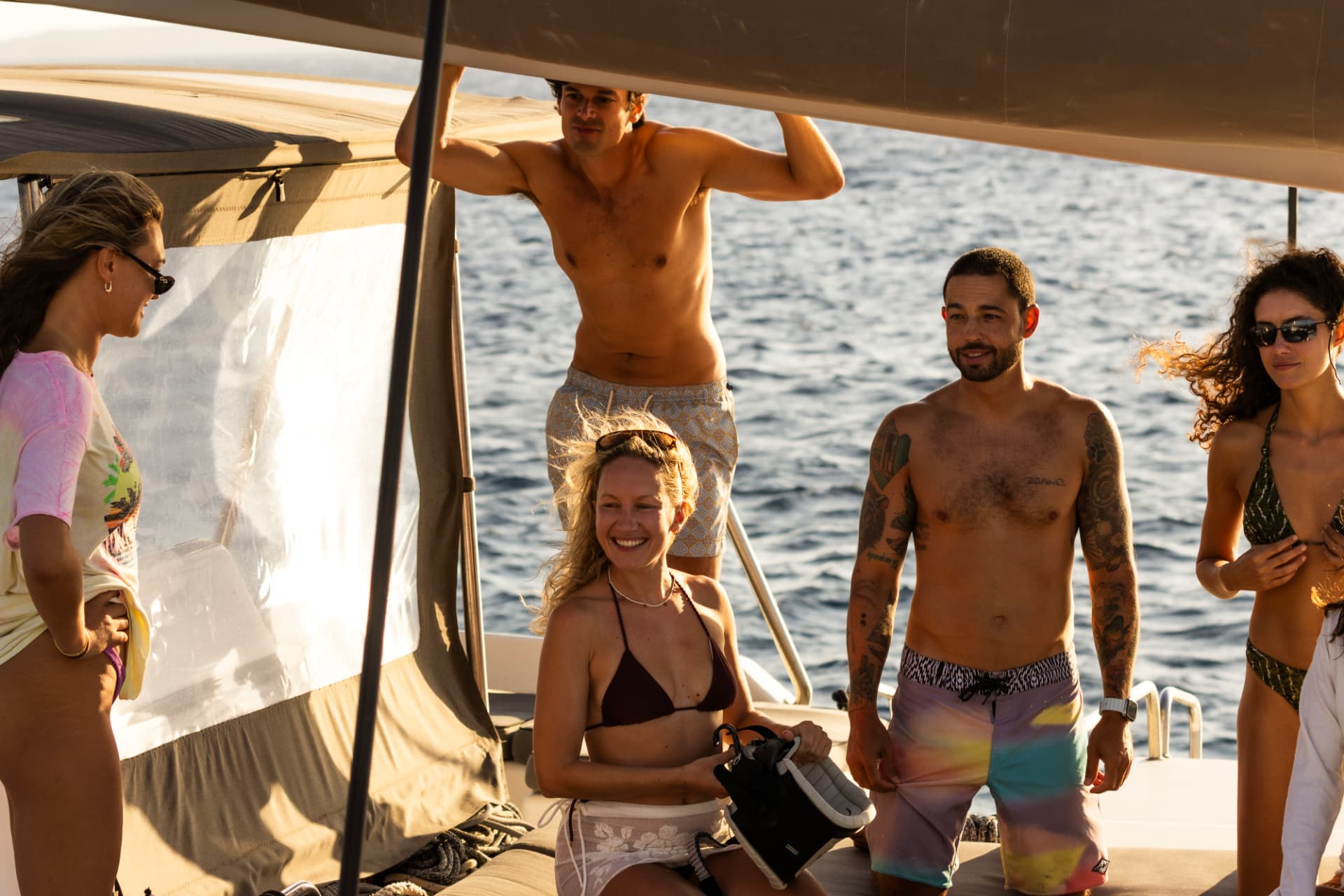Guests and crew celebrating on deck at sunset
