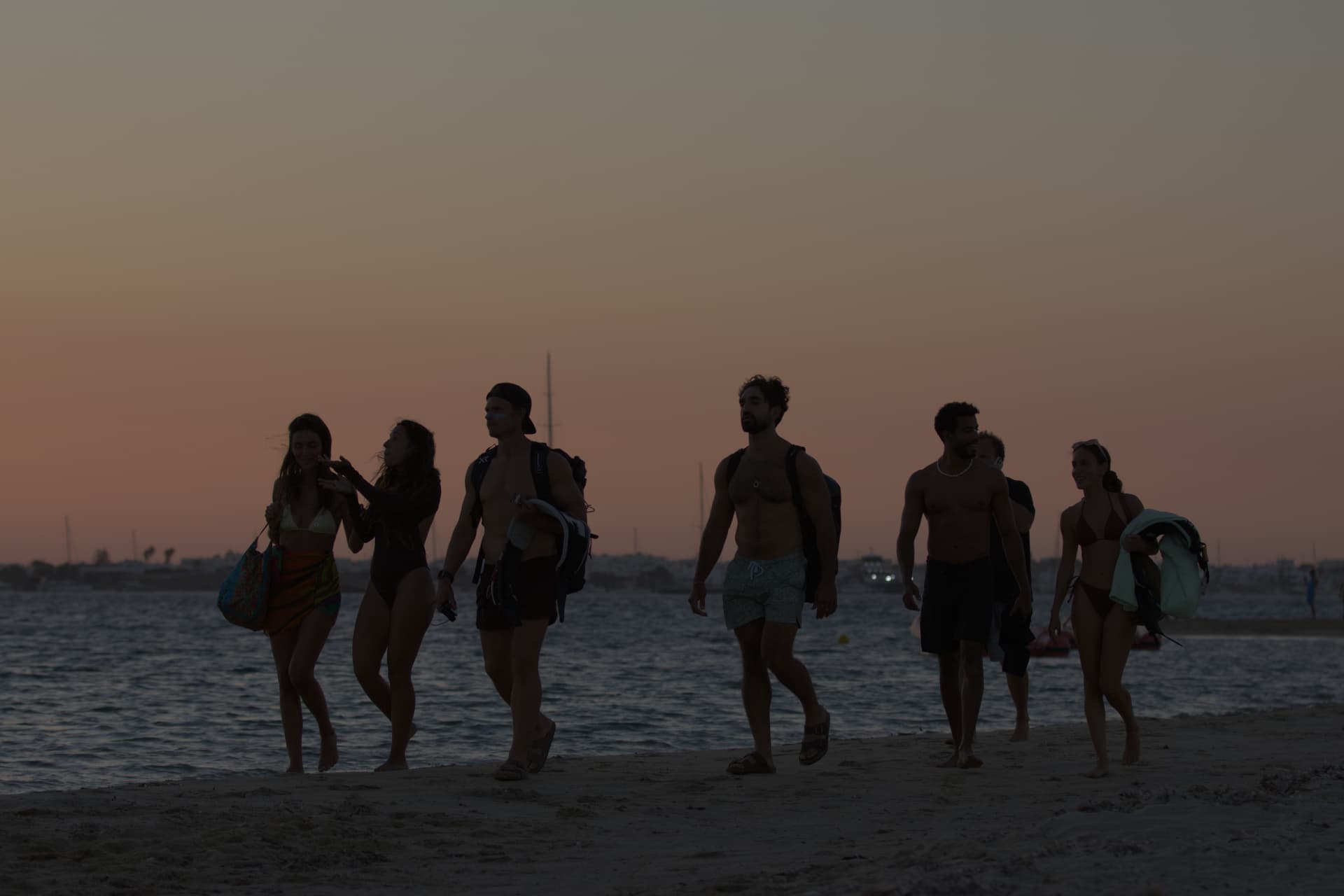 Crew walking the beach at sunset