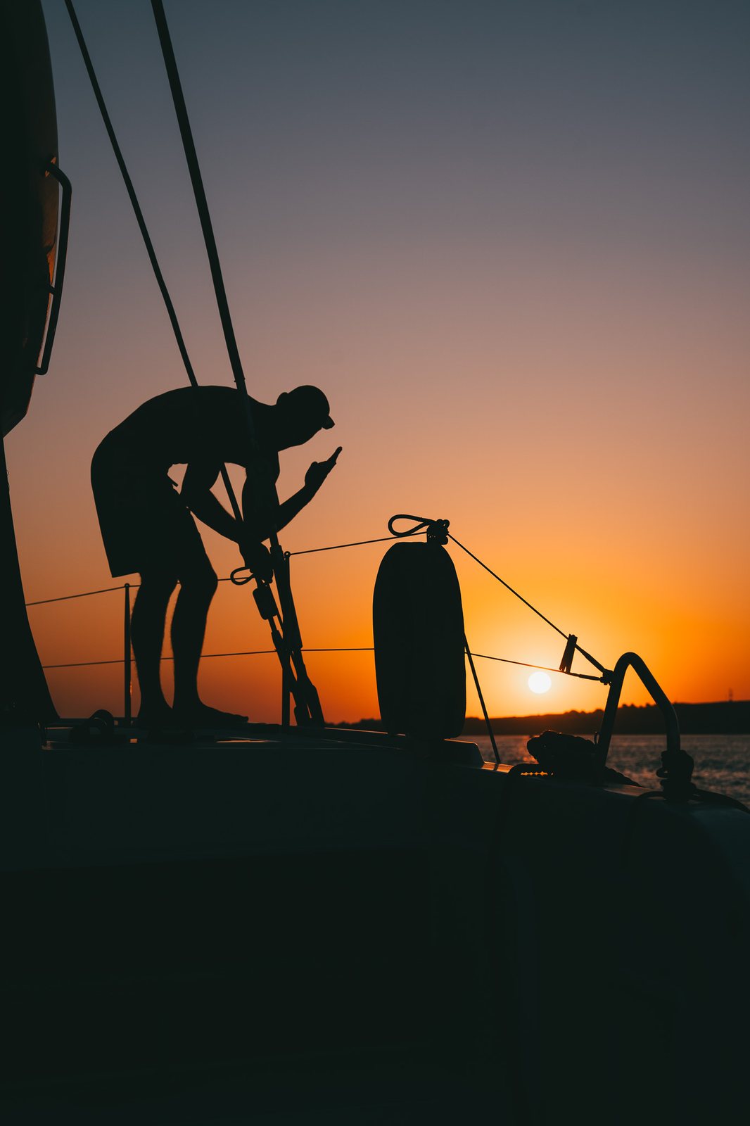 Crew silhouette working the rigging at sunset