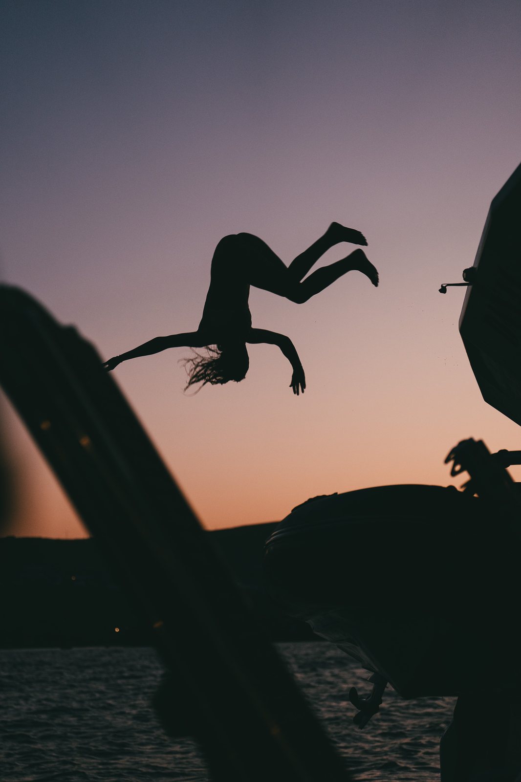 Guest diving off the deck at dusk, silhouetted
