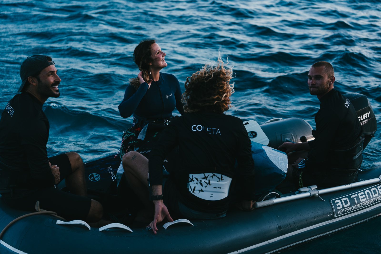Crew and guests chatting in the dinghy at dusk