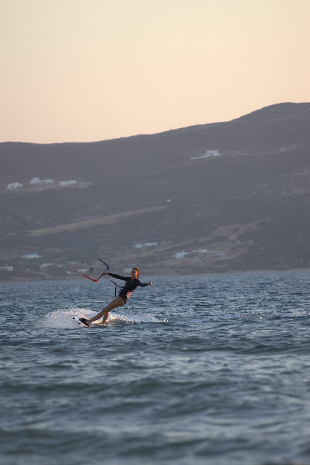 Kitesurfer carving at golden hour