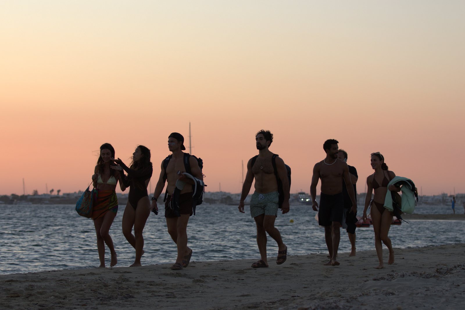 Crew walking along the beach at dusk