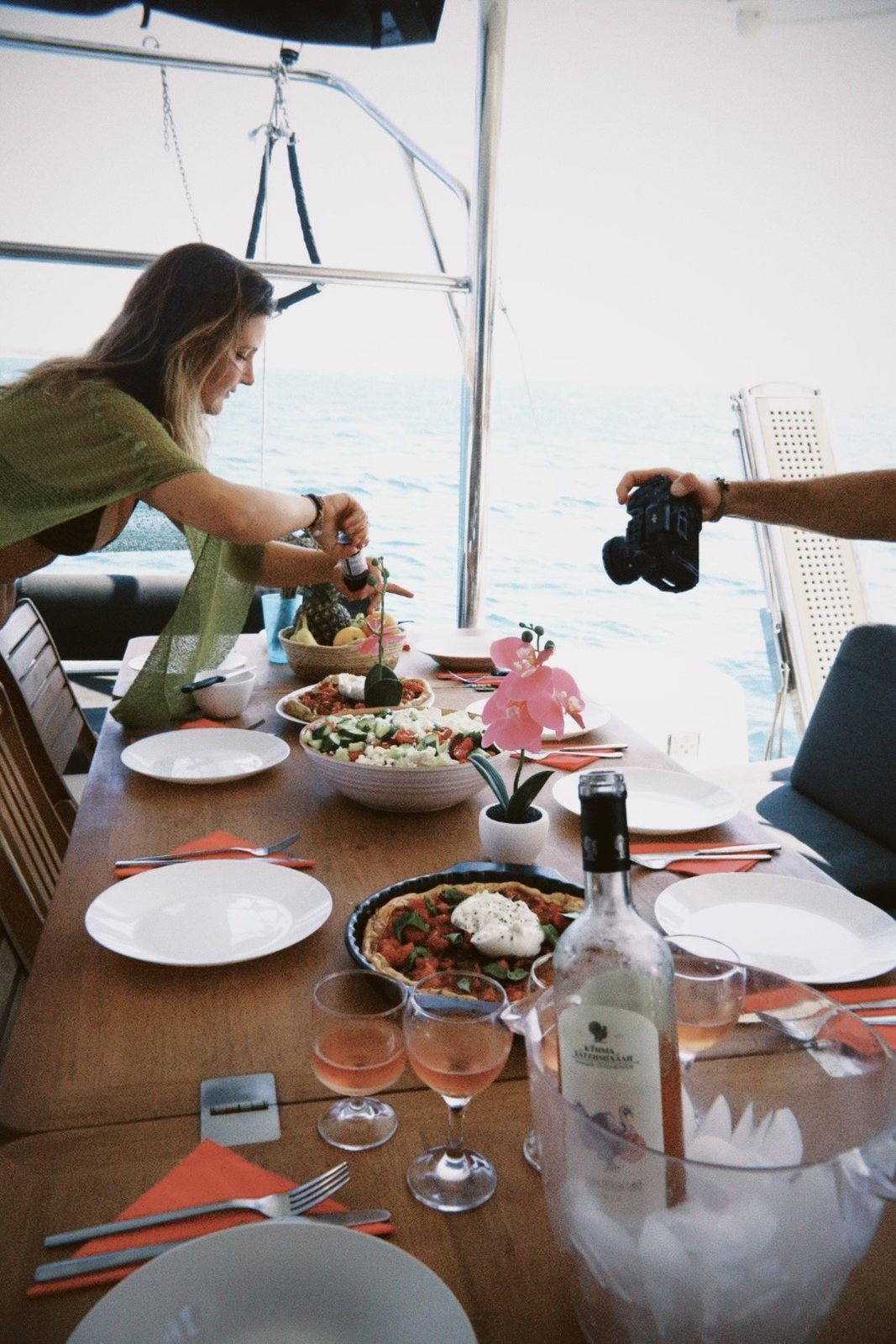 Dinner being served on deck with rosé on the table