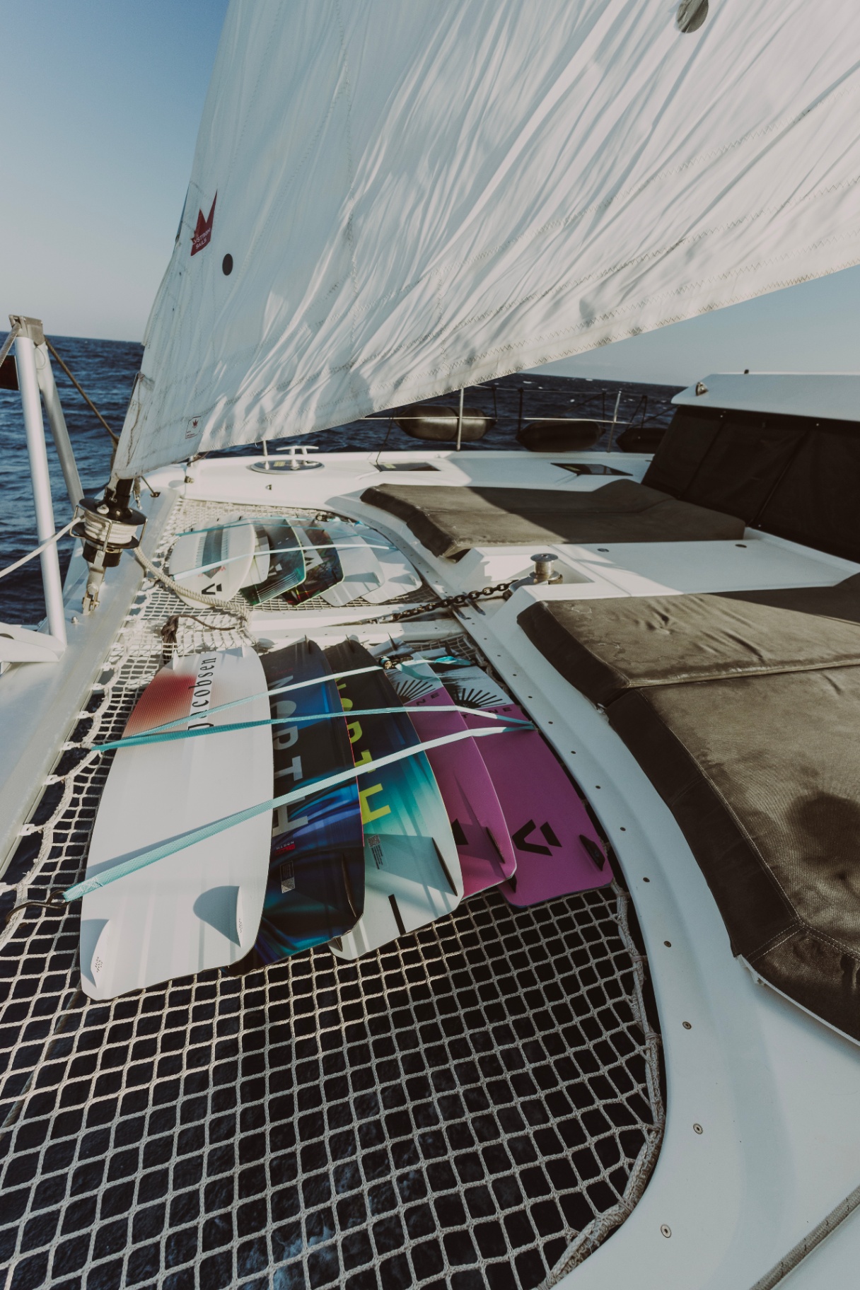 Kiteboards lashed to the trampoline under full sail