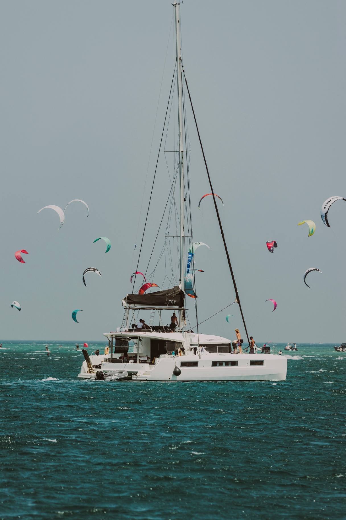 Catamaran anchored among a sky full of kites