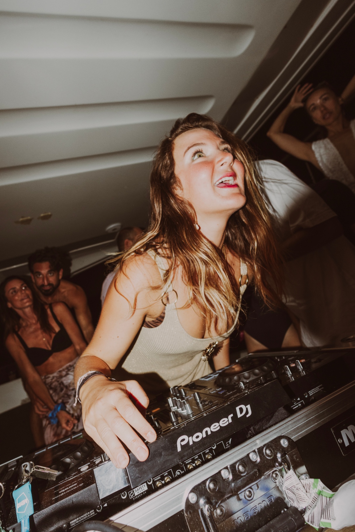 Guest dancing behind the decks at night