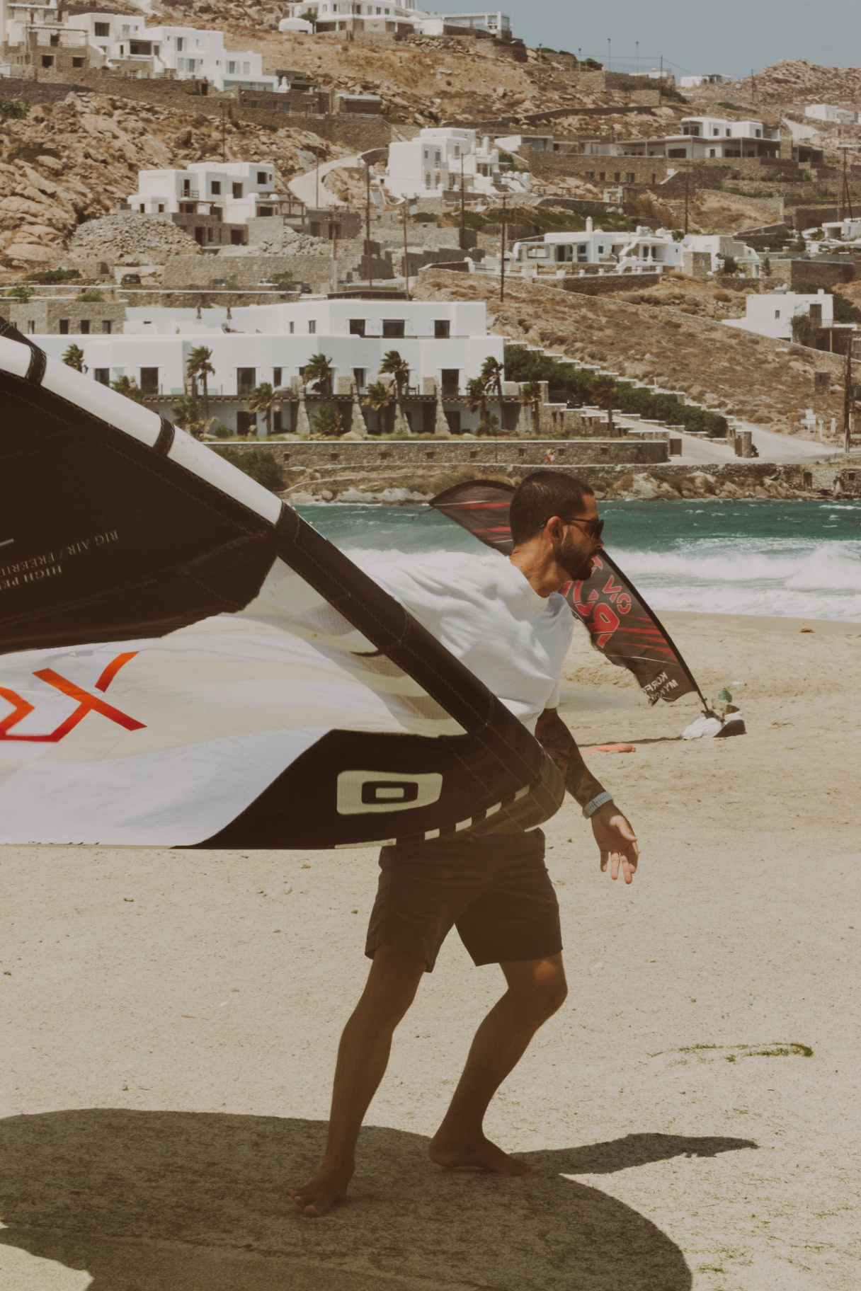 Rider walking a kite down the beach