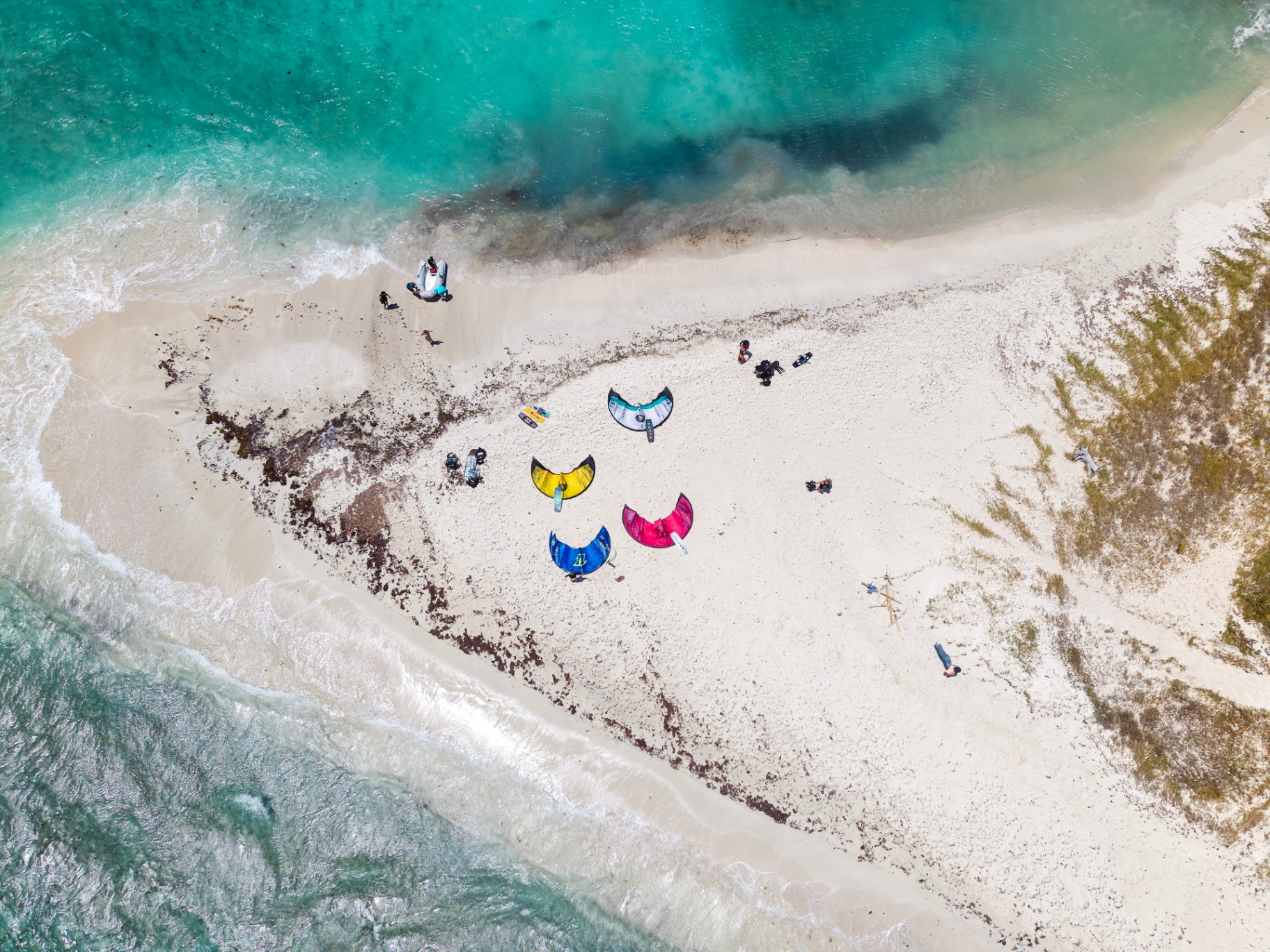 Aerial view of kites laid out on a white sandbar