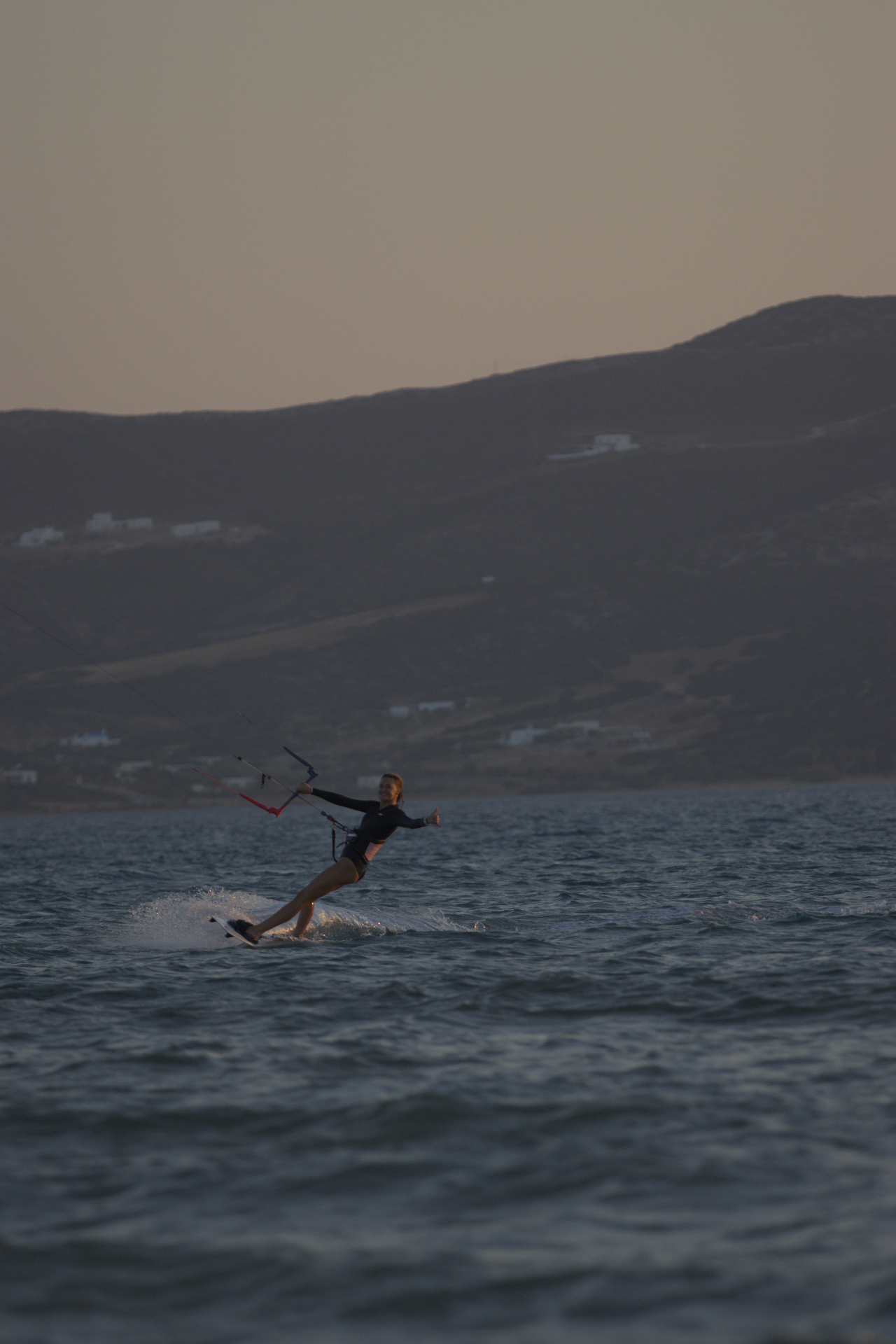 Rider giving a thumbs-up while carving at dusk