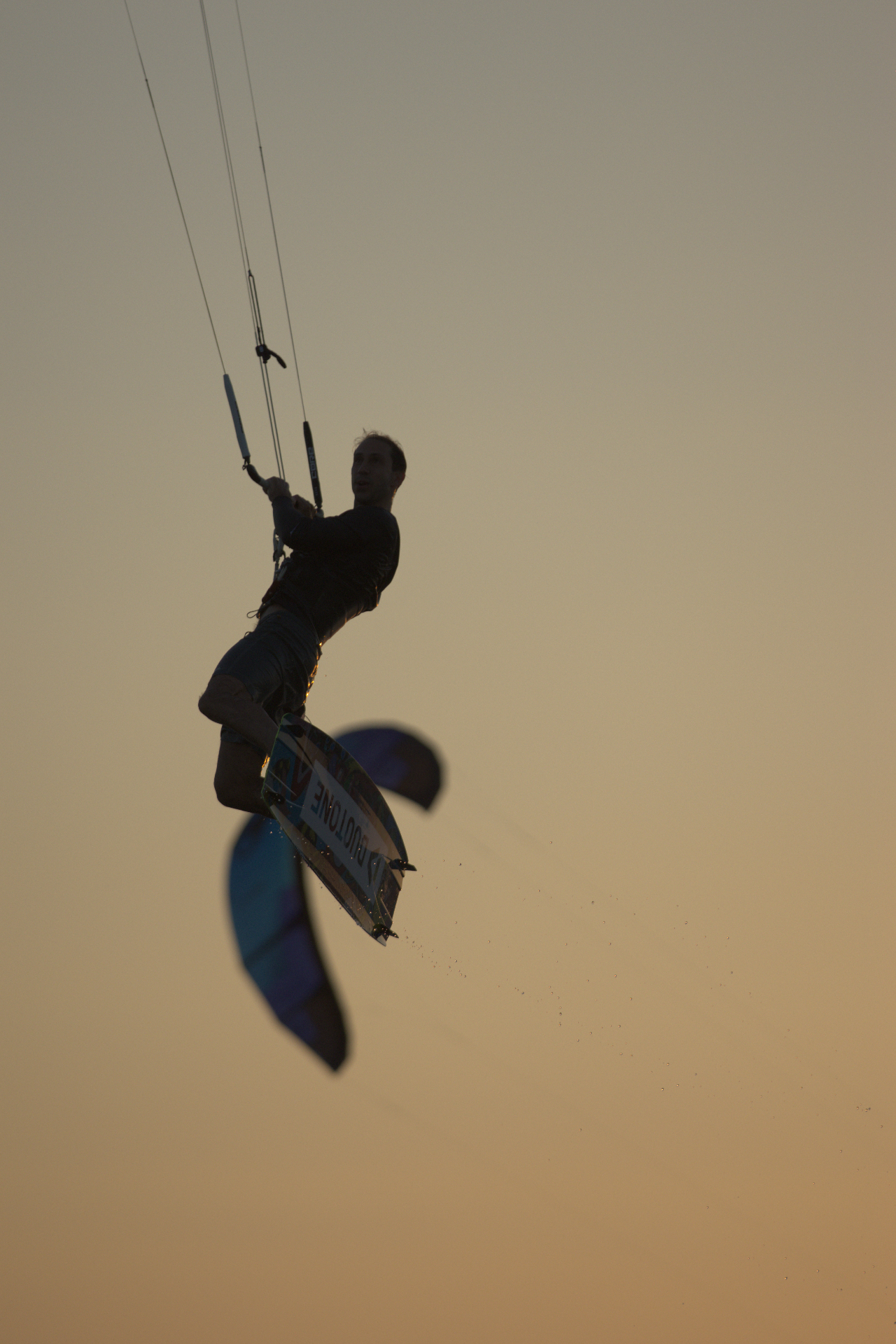 Rider silhouetted mid-jump against an amber sky