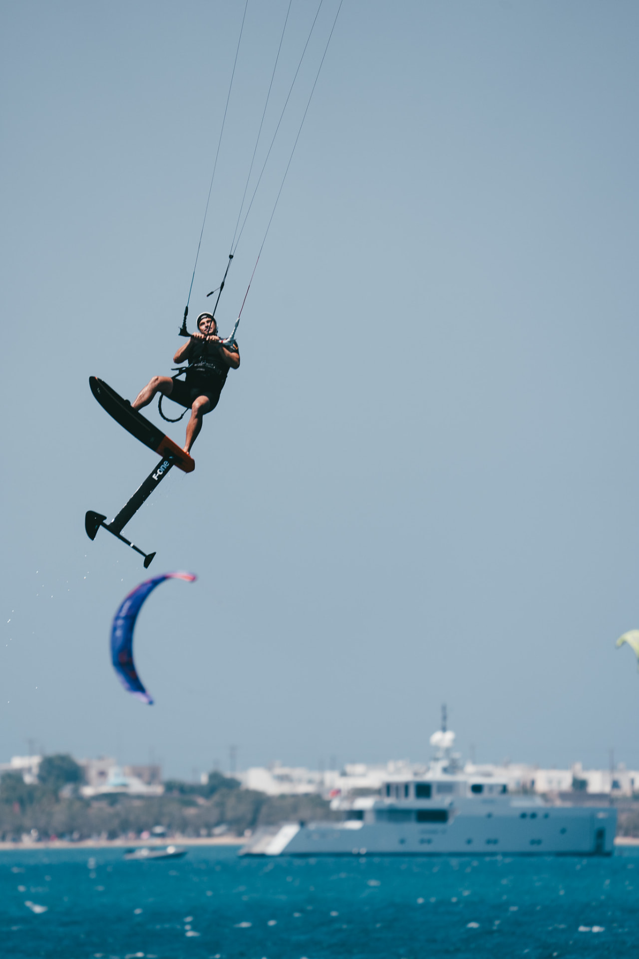 Foil rider mid-air above the bay